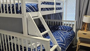 Ein Schlafraum mit Etagenbetten, einem Fenster und Vorhängen.