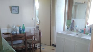 A kitchen with a dining table, chairs, a refrigerator, and a sink. - SUNNY HOUSE, LAND RAISED (Aubenas)