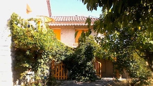 A narrow pathway leading to a building with a tiled roof and a wooden gate. - SUNNY HOUSE, LAND RAISED (Aubenas)