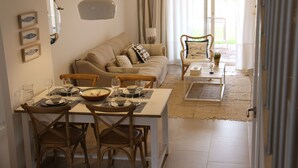 Un comedor con una mesa lista para cuatro personas, un sofá y una silla.