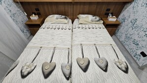 Ein Doppelbett mit herzförmigen Kissen und einer Strickdecke.