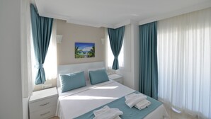 Une chambre d’hôtel avec un lit, une table de chevet, un tableau et des rideaux.