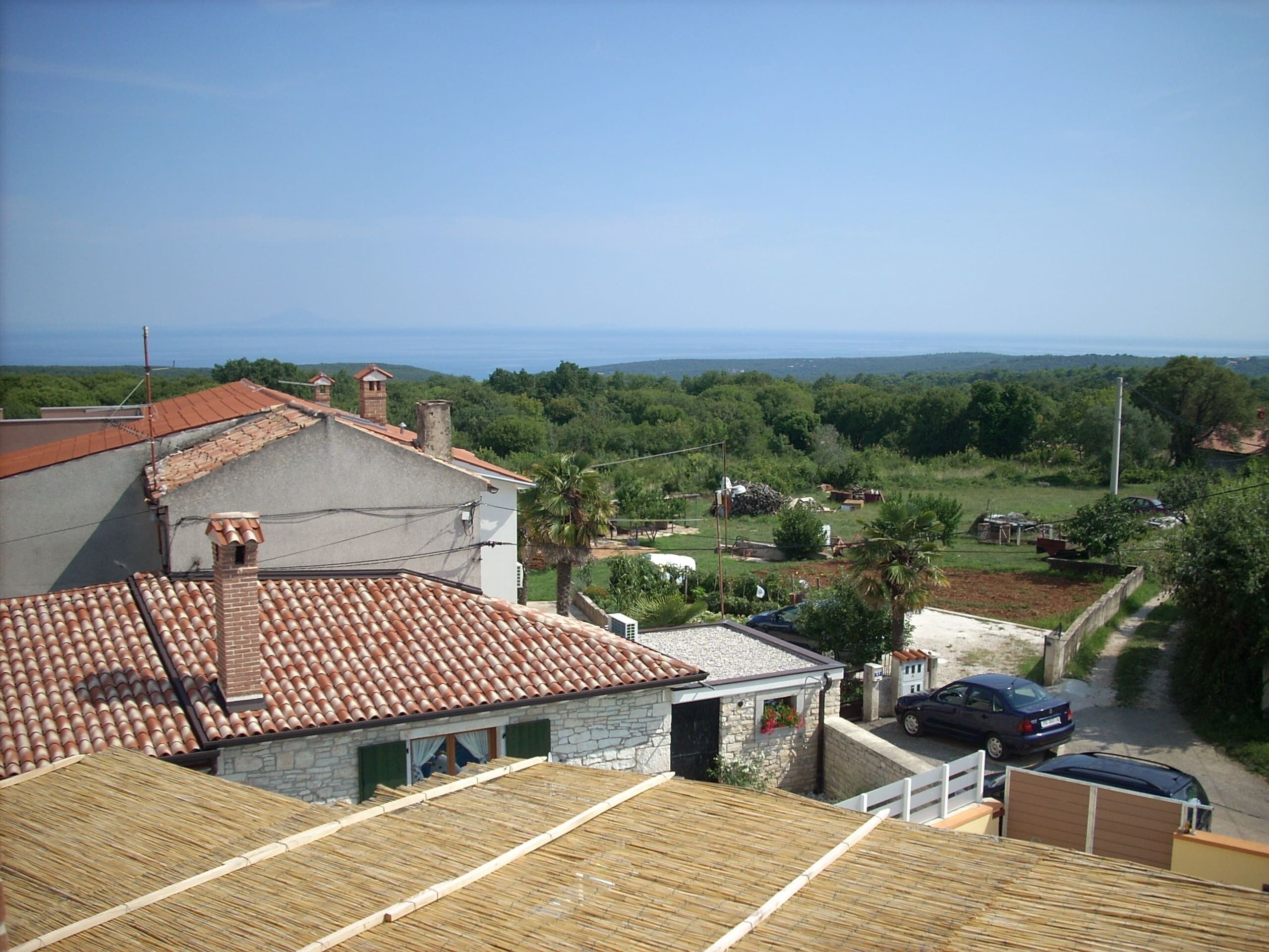 A residential area with a house featuring a tiled roof and a stone wall.