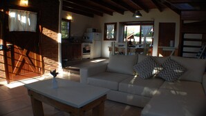 Una sala acogedora con un sofá, una mesa de centro y una cocina al fondo.