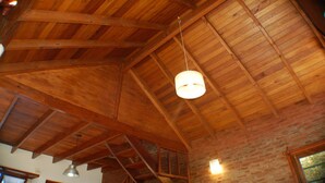 Una habitación con vigas de madera a la vista y un candelabro colgante.