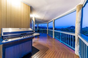 A covered outdoor area with a barbecue grill, wooden deck, and a view of the landscape. - Sunset Escape - Cannonvale (Cannonvale)