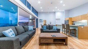 Una sala de estar moderna con un sofá, una mesa de centro y un comedor con sillas.