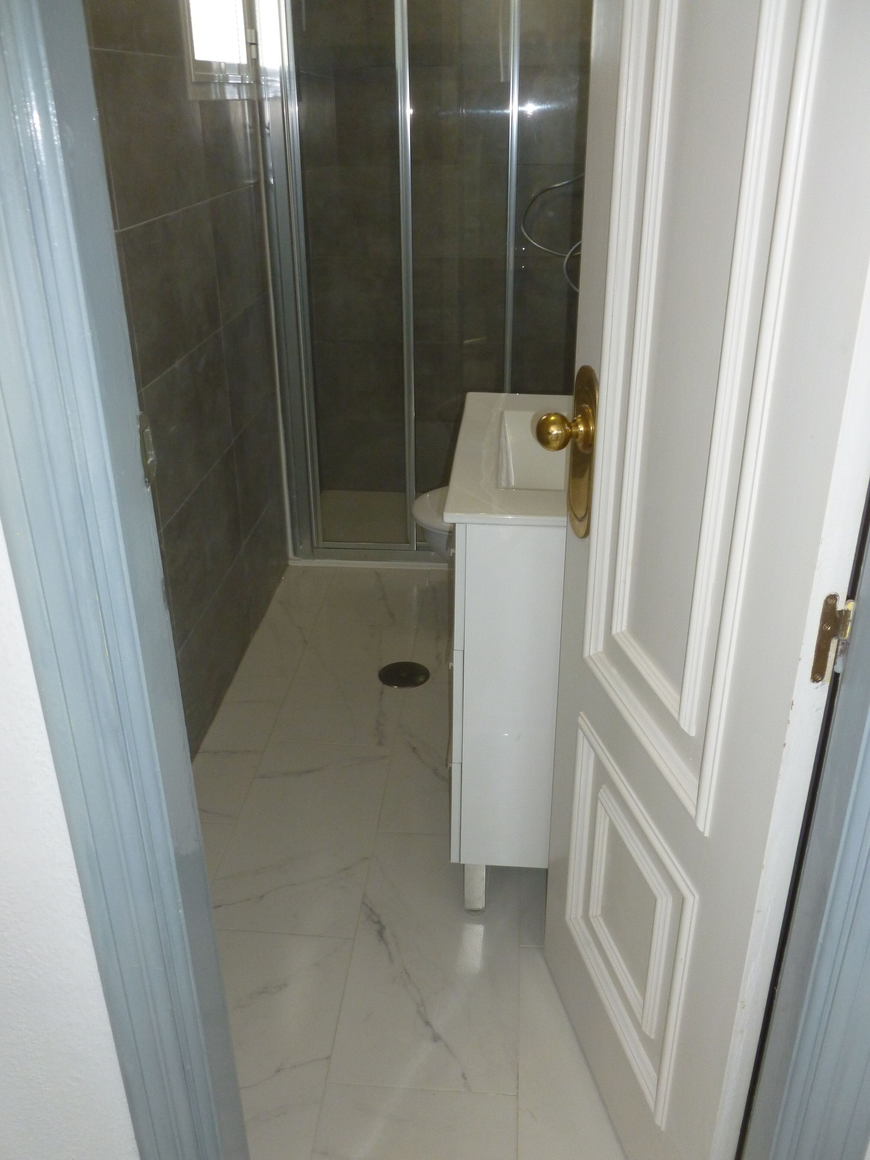 Ein Badezimmer mit Dusche, Toilette und Waschbecken.