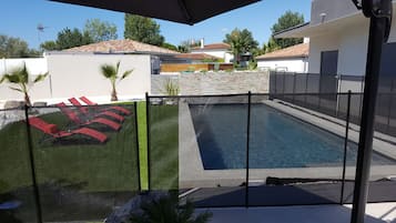 Relax by the clear pool surrounded by lush greenery and comfortable lounge chairs.