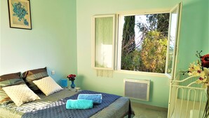 A bedroom with a bed, pillows, a window, and a radiator. - L 'OLIVADE LARGE RECENT VILLA WITH PANORAMIC VIEW  (Entrecasteaux)