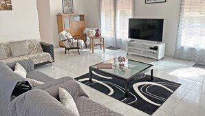 Un salon moderne comprenant un canapé, une table basse, un téléviseur et un meuble.