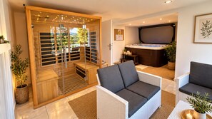 A modern interior with a sauna, seating area, and a hot tub.