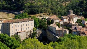 A historic town with a prominent stone building and a tower, surrounded by lush greenery. - L 'OLIVADE LARGE RECENT VILLA WITH PANORAMIC VIEW  (Entrecasteaux)