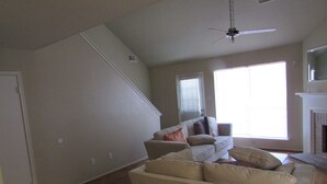 A living room with a sofa, a fireplace, and a staircase. - Houston Near Stadium, Galleria and Downtown (Houston)