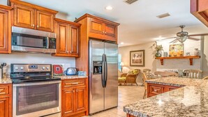 A kitchen with wooden cabinets, stainless steel appliances, and a granite countertop.