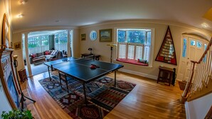 A spacious room with a ping pong table, a sofa, and a staircase. - The Best VRBO In Colorado Springs.  Our Reviews Prove It.  Near All The Venues  (Colorado Springs)
