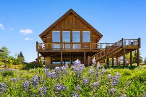 A wooden cabin with a balcony and a staircase leading to an upper level. - Bear Vista (Crested Butte)