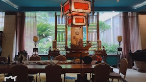 A traditional dining area with a large table, chairs, and a decorative centerpiece. - Prdeiction Hotel (Guilin)