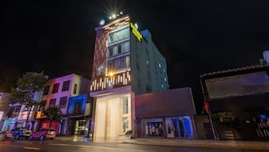 Un hotel con fachada moderna, varios pisos y señalización iluminada.