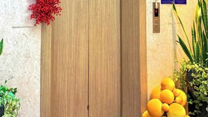 Puerta de madera con una guirnalda decorativa de bayas rojas y un abanico.
