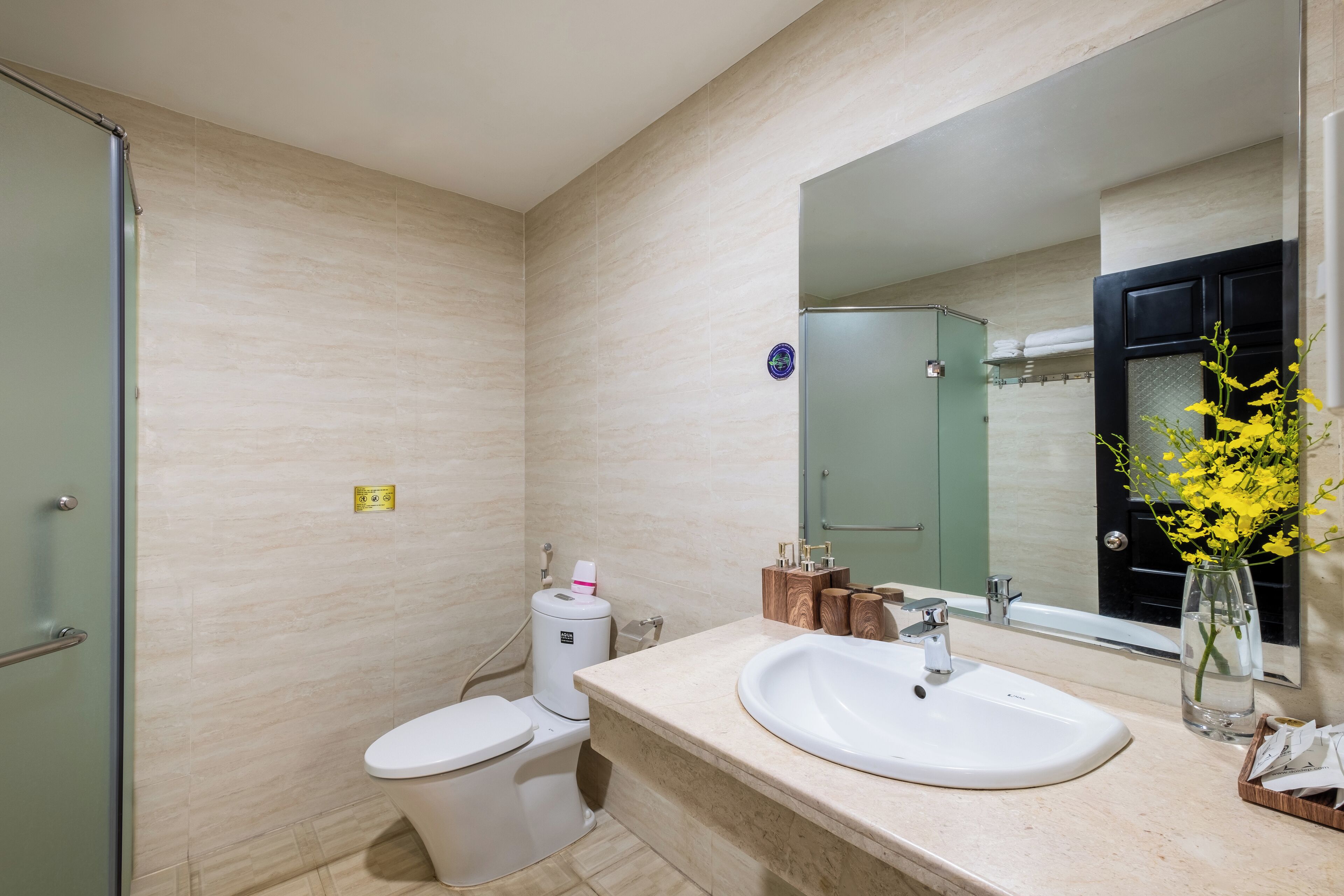 A modern bathroom with a toilet, sink, and mirror.