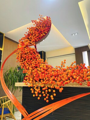 A modern interior with a unique art installation featuring orange and yellow spherical elements. - Sandals Hotel (B'Lao)