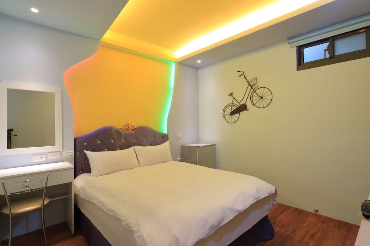 Ein Schlafzimmer mit Bett, Schreibtisch, Stuhl, Spiegel und einem an der Wand befestigten Fahrrad-Dekoration.