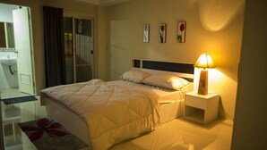 Une chambre d’hôtel avec un lit, une table de chevet, une lampe et une œuvre d’art accrochée au mur.