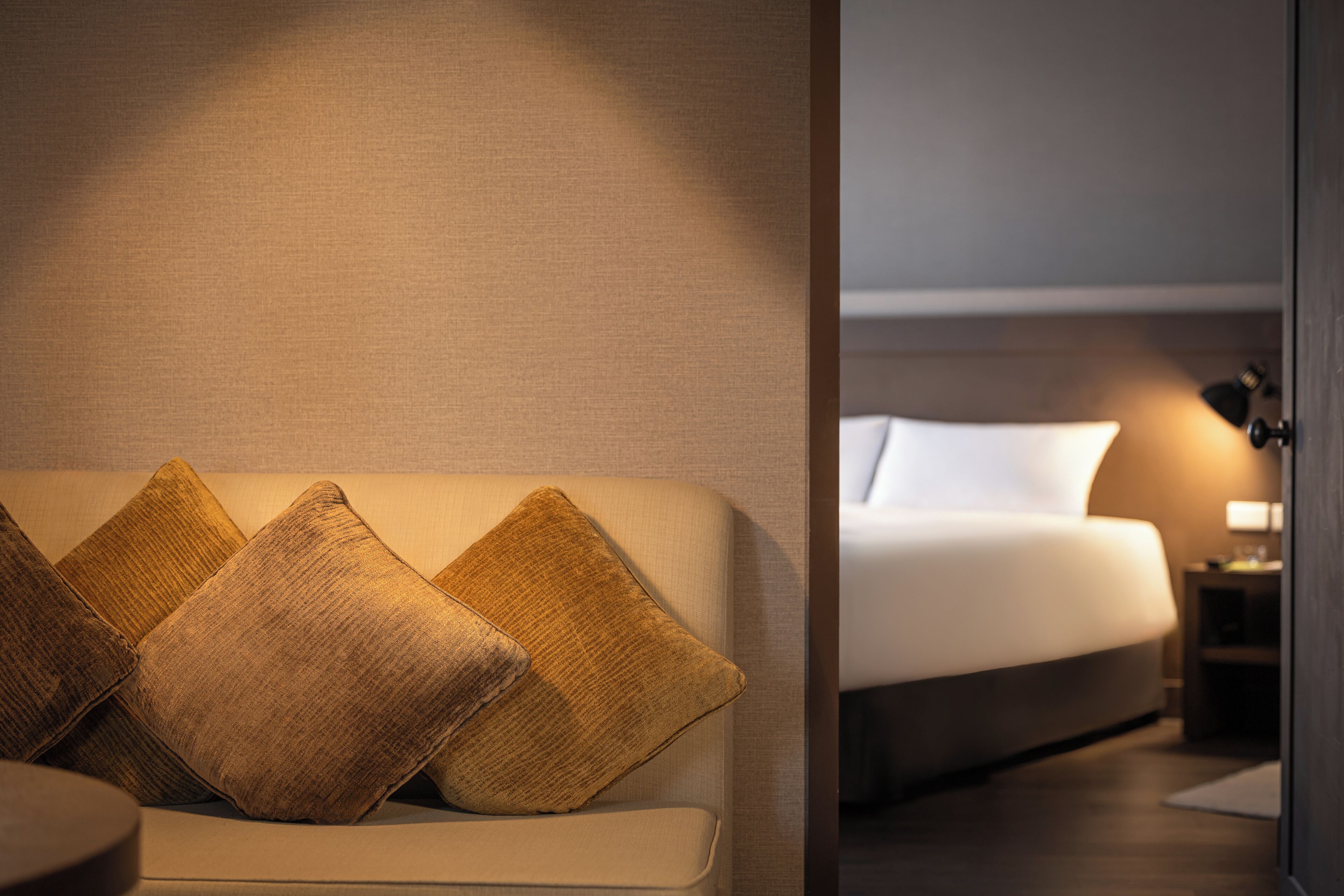 A modern hotel room with a sofa and a bed.