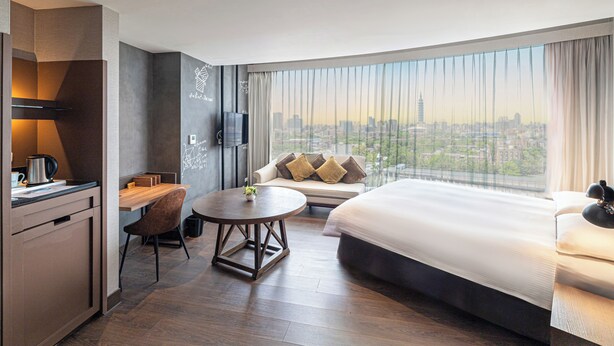 A hotel room with a city view, a dining area, and a bed. - Just Sleep Taipei NTU (Taipei)
