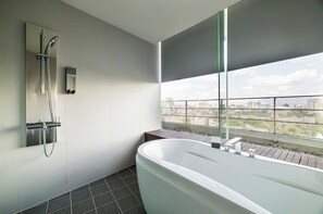 Exclusieve driepersoonskamer | Badkamer | Een haardroger, handdoeken, zeep, shampoo