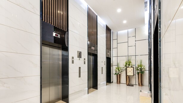 A modern elevator area with marble walls, a digital display showing the number 3, and a potted plant. - GOLDEN CENTRAL SERVICED RESIDENCE SHENZHEN (UPPER HILLS) (Shenzhen)