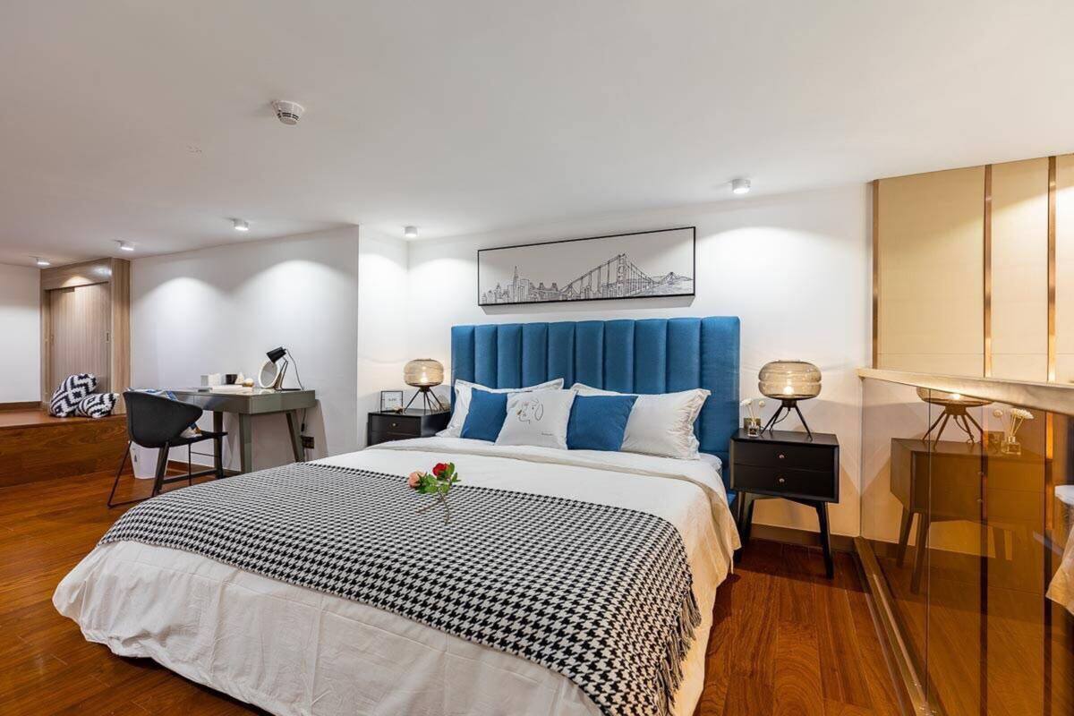 Une chambre d’hôtel moderne, dotée d’un grand lit, d’un bureau et d’une chaise.