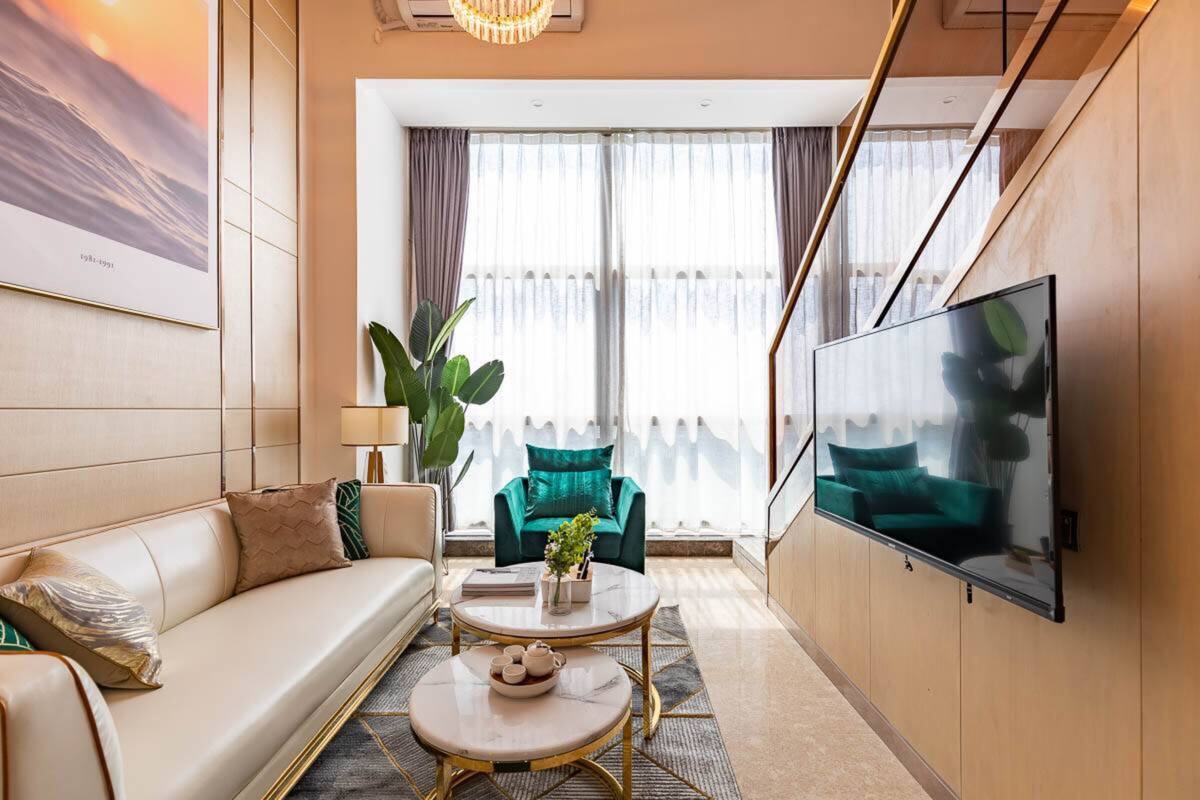 Un salon moderne avec un canapé, une table basse et un téléviseur fixé au mur.
