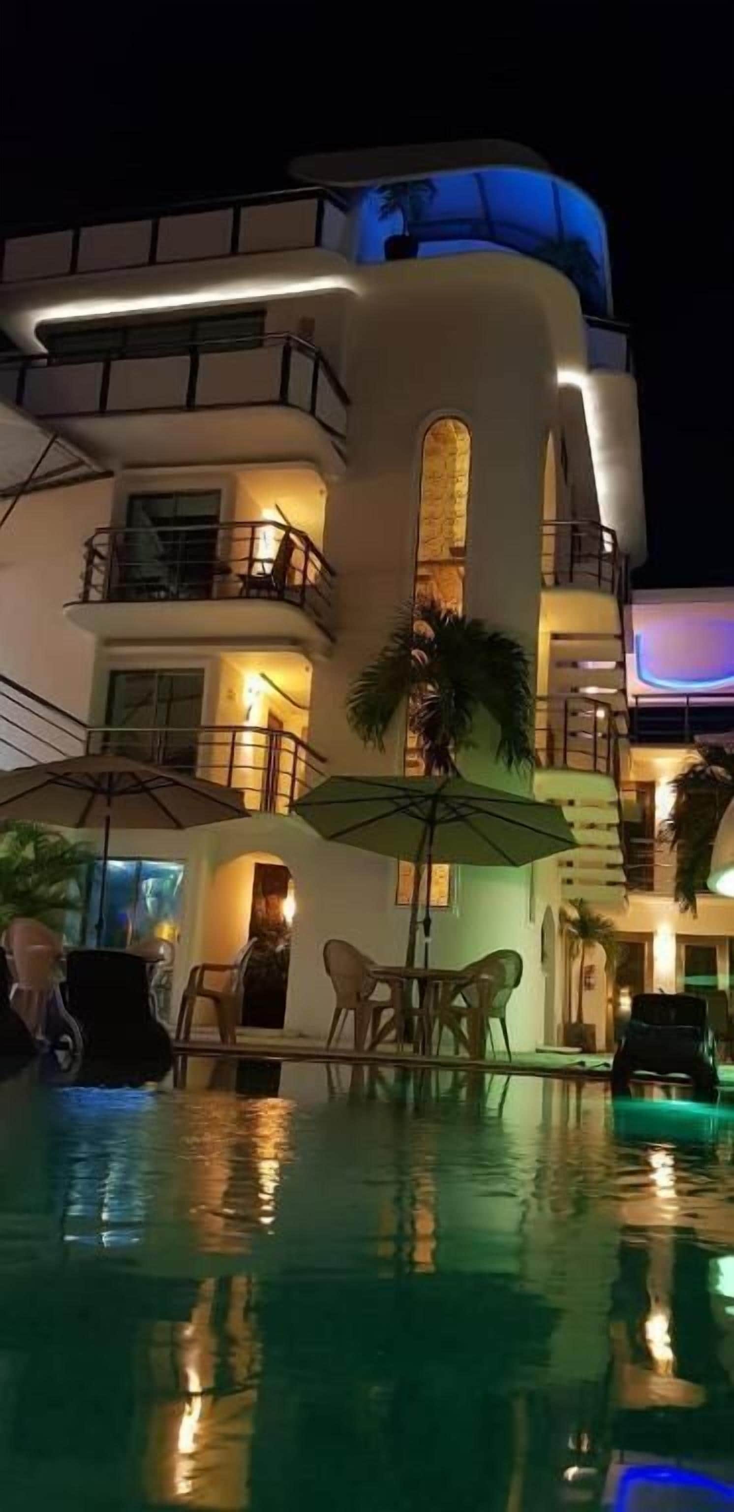 A hotel with a pool, outdoor seating, and a modern architectural design.