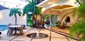 A modern indoor space with a dining area, seating, and a water feature. - Hotel Blue Star Cancun (Cancun)