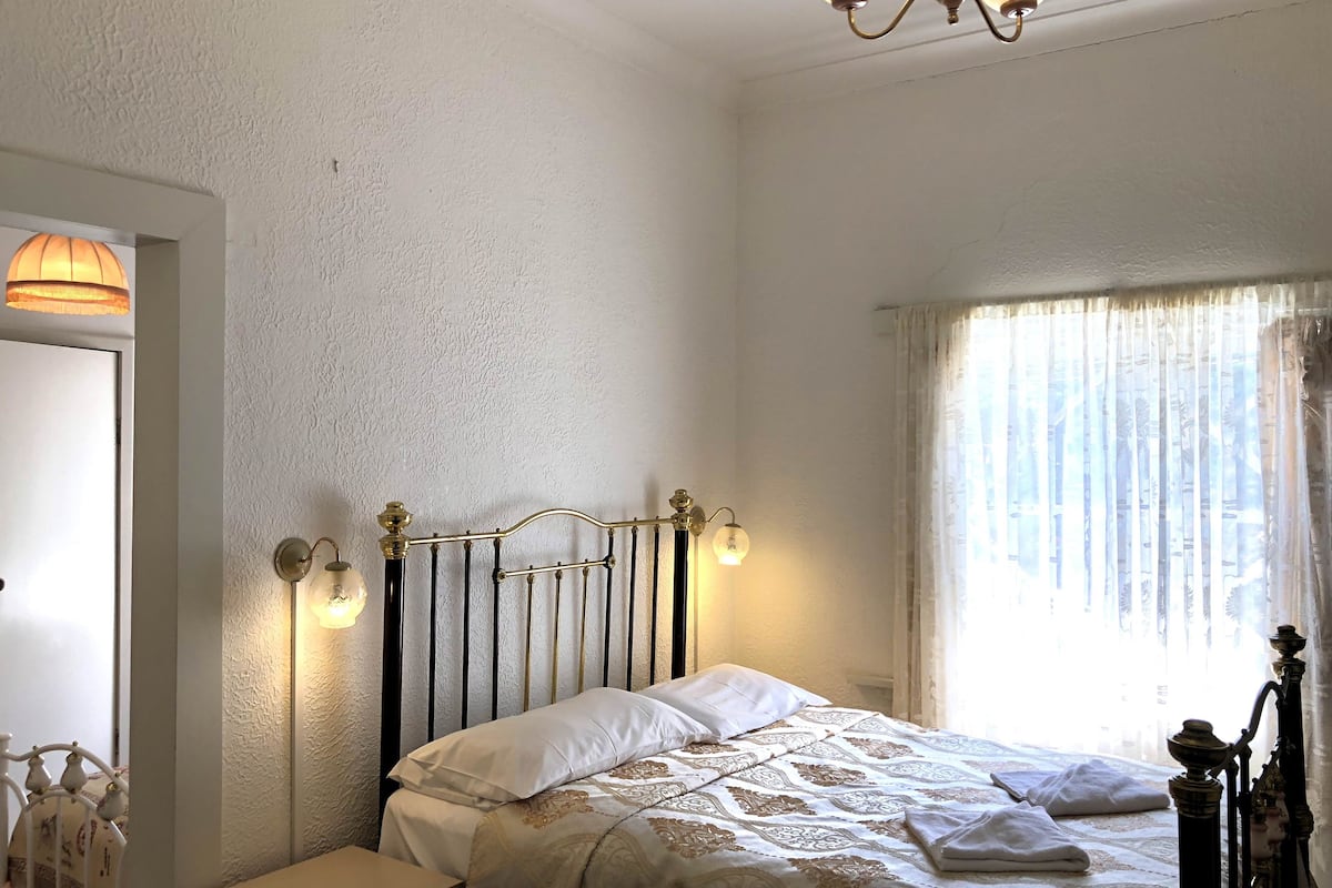 A bedroom with a bed, bedside table, and a nightstand.