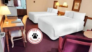 A hotel room with two beds, a desk, a chair, and a small table.