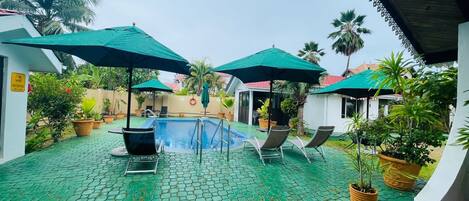 Piscine extérieure, parasols de plage, chaises longues