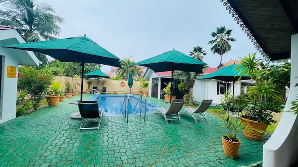 Piscine extérieure, parasols de plage, chaises longues