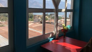 Una habitación con un ventanal grande que da a un paisaje montañoso.