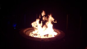 A fire pit with flames. - Hillscapes (Port Alfred)