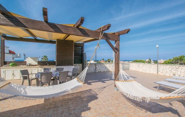A rooftop terrace with a wooden pergola, outdoor seating, and hammocks. - Amazing apartment in Bari with WiFi (Bari)