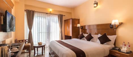Una habitación de hotel con una cama grande, mesitas de noche, un escritorio y una silla.