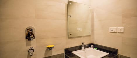 A modern bathroom with a large mirror, a sink, and a toilet.