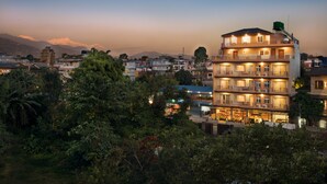 A multi-story hotel with balconies and a view of mountains in the background. - Hotel Lake Shore (Pokhara)