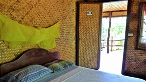 A room with a bed, a woven wall, and a door labeled "D-1". - Dabdab Tourist Inn (Puerto Princesa)