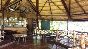 An open-air structure with a wooden floor and a thatched roof. - Dabdab Tourist Inn (Puerto Princesa)