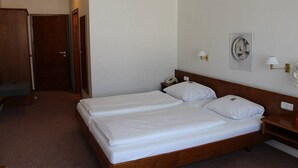 A hotel room with a double bed, bedside tables, a telephone, and a wall-mounted light fixture. - Hotel Post Rosbach (Rosbach vor der Hoehe)