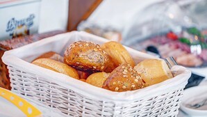 A basket of various breads and pastries, including rolls and buns with seeds. - Hotel Post Rosbach (Rosbach vor der Hoehe)